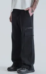 Pantalón de jogging negro de frisa con cintura y puños elásticos, bolsillos laterales, trasero y lateral con cierre.