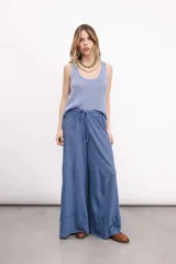 Pantalón palazzo azul de lino tejido, tiro medio con elástico en la cintura y pierna ancha con refajo inferior.