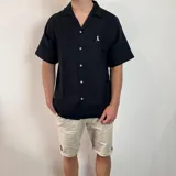 Camisa negra de muselina con manga corta y corte oversize.