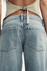 Pantalón de jean celeste claro, de tiro bajo, corte wide leg y largo hasta el tobillo. Tiene cinco bolsillos, cierre frontal con cremallera y botón metálico.