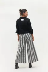 Pantalón de jean con corte palazzo y estampado a rayas verticales en tonos grises.