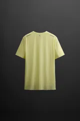 Camiseta deportiva color amarillo claro confeccionada en tejido técnico ligero y elástico. Cuenta con cuello redondo, manga corta, costuras termofijadas y estampaciones reflectantes en la espalda.