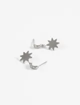 Aros colgantes dorados con dije de estrella de ocho puntas.