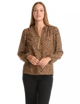 Blusa de gasa estampada con animal print, cuello a la base con escote en V y cierre dorado. Manga larga con puño elastizado.