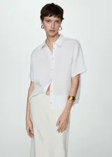 Camisa blanca de lino con cuello clásico, manga corta y cierre frontal con botones.