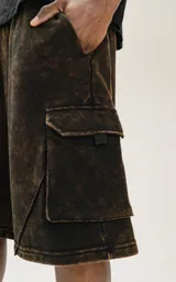 Bermuda estilo cargo color marrón óxido, con recortes, bolsillos laterales y bolsillos con tapa de calce oversize confeccionada en rústico 100% algodón con proceso de desgaste.