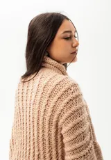 Sweater de punto grueso color rosa viejo, con cuello alto, mangas largas y corte oversize. Tejido en 100% lana Merino.