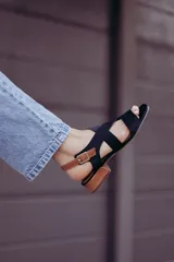 Sandalias de cuero color beige con tiras cruzadas y hebilla lateral. Taco cuadrado color marrón oscuro.