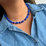 Collar corto de cuentas rojas con forma de barril alternadas con cuentas plateadas redondas.