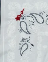 Pañuelo celeste con estampado paisley y bordado de flores rojas.