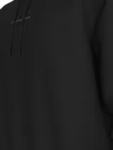 Buzo negro de felpa con capucha y cordón ajustable. Tiene puños y bajo de canalé. Presenta un monograma bordado de Calvin Klein en el pecho.