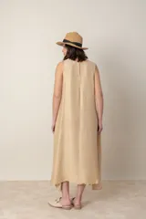 Vestido midi marrón de tejido tramado, corte suelto, sin mangas y con bolsillos laterales.