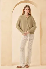 Campera con capucha color beige, de punto inglés con terminaciones rotas en los puños y bordado artesanal en la espalda con motivos marinos.