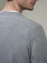 Sweater gris de algodón con cuello redondo.