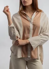 Camisa color beige con solapas y cierre con botones.