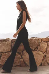 Pantalón negro de tiro alto confeccionado en tejido de punto elástico y flexible con trama compacta, mullida y opaca. Bajo acampanado.