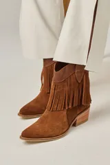 Bota tejana de cuero vacuno color marrón con flecos en la caña, taco de 5.5 cm y caña de 17 cm.