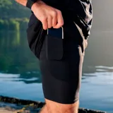 Short de compresión negro para hombre, de poliéster y spandex, con paneles de malla, cintura elástica, bolsillo lateral y calce regular.