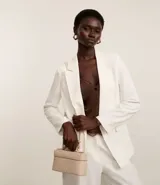 Cartera femenina tipo baú pequeña color beige, con textura tressê, correa de mano fija, cierre por cremallera y asa larga desmontable.