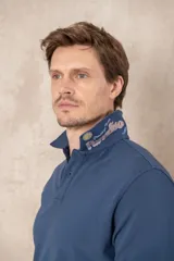 Remera tipo polo color beige, de manga corta y corte clásico. Tiene cuello con botones y está confeccionada en algodón.