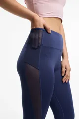 Calza deportiva larga negra con cintura alta, detalles de transparencias laterales en tul y bolsillos laterales.