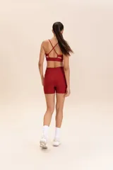 Top deportivo verde oliva con tirantes finos cruzados en la espalda y relleno extraíble.