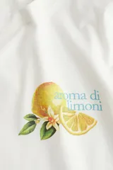 Remera blanca de corte holgado en punto de algodón. Modelo con cuello redondo y estampado de limones con texto en el frente.