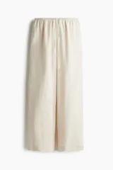 Pantalón de lino color crema, de corte holgado, con cintura elastizada y cordón de ajuste.