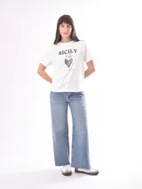 Remera rosa con estampado de labios rojos y texto con tipografía retro.