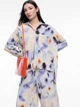 Camisa de manga larga confeccionada en viscosa crinkled con estampa de manchas. De silueta amplia y fluida, con bolsillos frontales grandes, tajos laterales y largo extendido en la espalda.