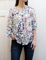 Blusa estampada marca Grand & Greene, con cuello a la base y escote en V. Tiene mangas 3/4 con puños elásticos fruncidos.