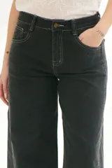 Pantalón de jean acampanado color caramelo con cintura alta y cinturón marrón con tachas.