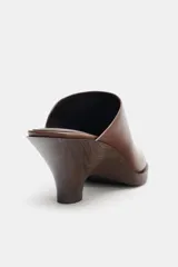 Zueco de cuero marrón con tacón de madera y punta redonda.