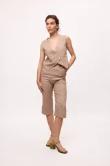 Chaleco marrón con escote en V y cierre cruzado con dos botones.