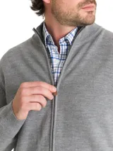 Sweater gris de lana merino extrafina, con cuello alto, cierre completo y bolsillos frontales.