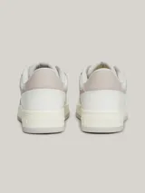 Zapatillas urbanas Tommy Jeans de corte bajo, con exterior de piel en tonos blanco, gris y beige. Presentan suela gruesa de goma, cordones y logo de la marca en el lateral y el talón.