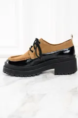 Mocasín abotinado con capellada combinada en cuero color marrón y charol negro.