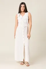 Vestido largo blanco sin mangas con cuello en V y cierre de botones delanteros. Incluye cinturón ancho a tono y bolsillos estilo safari en el pecho.