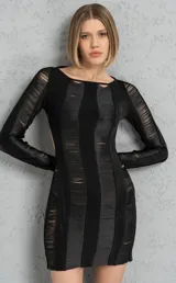 Vestido corto negro con tajos y espalda descubierta, de mangas largas y corte ajustado.