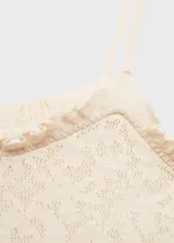 Vestido largo de punto fino color crudo, con tirantes finos, escote recto con volados y detalles calados. Diseño entallado.