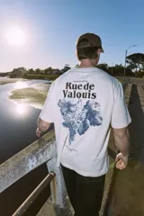 Remera de algodón color crudo, corte holgado, cuello redondo y manga corta. Estampa en la espalda con diseño de uvas y texto "Creative Studio Rue de Valois".