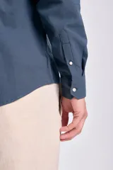 Camisa de lino azul oscuro de corte clásico, con cuello abotonado y bolsillo en el pecho.