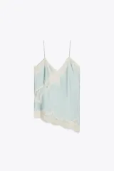 Top lencero celeste con escote en V, tirantes finos y detalle de encaje blanco en el escote y el ruedo asimétrico.