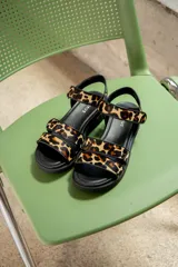 Sandalias con plataforma de cuero negro y tiras con estampado animal print.