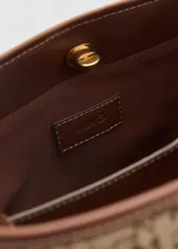 Bolso tipo tote de tamaño mediano, color beige con monograma de la marca en marrón. Tiene cierre de tuerca, asa de hombro ajustable con hebillas y bolsillo interior.