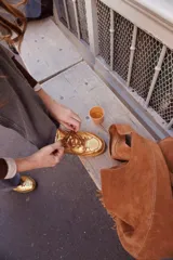 Championes deportivos de cuero y gamuza color dorado metalizado y marrón. Suela de caucho color crema con línea roja. Cordones color crema.