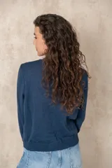 Cardigan celeste de tejido de punto, con cuello redondo y cierre frontal con botones.