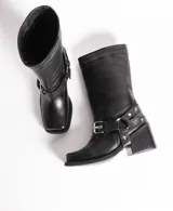 Bota de cuero color marrón oscuro, de caña media, con hebilla y tachas decorativas.