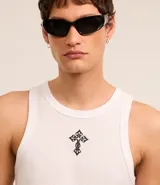 Musculosa blanca de algodón con cuello redondo, corte muscle y bordado de cruz texturizada en el pecho.