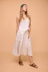 Pollera midi color beige de lino, con cintura ajustable con botón y bolsillo cargo en el lateral.